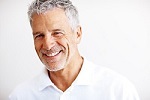 Closeup portrait of a handsome mature man smiling on white background